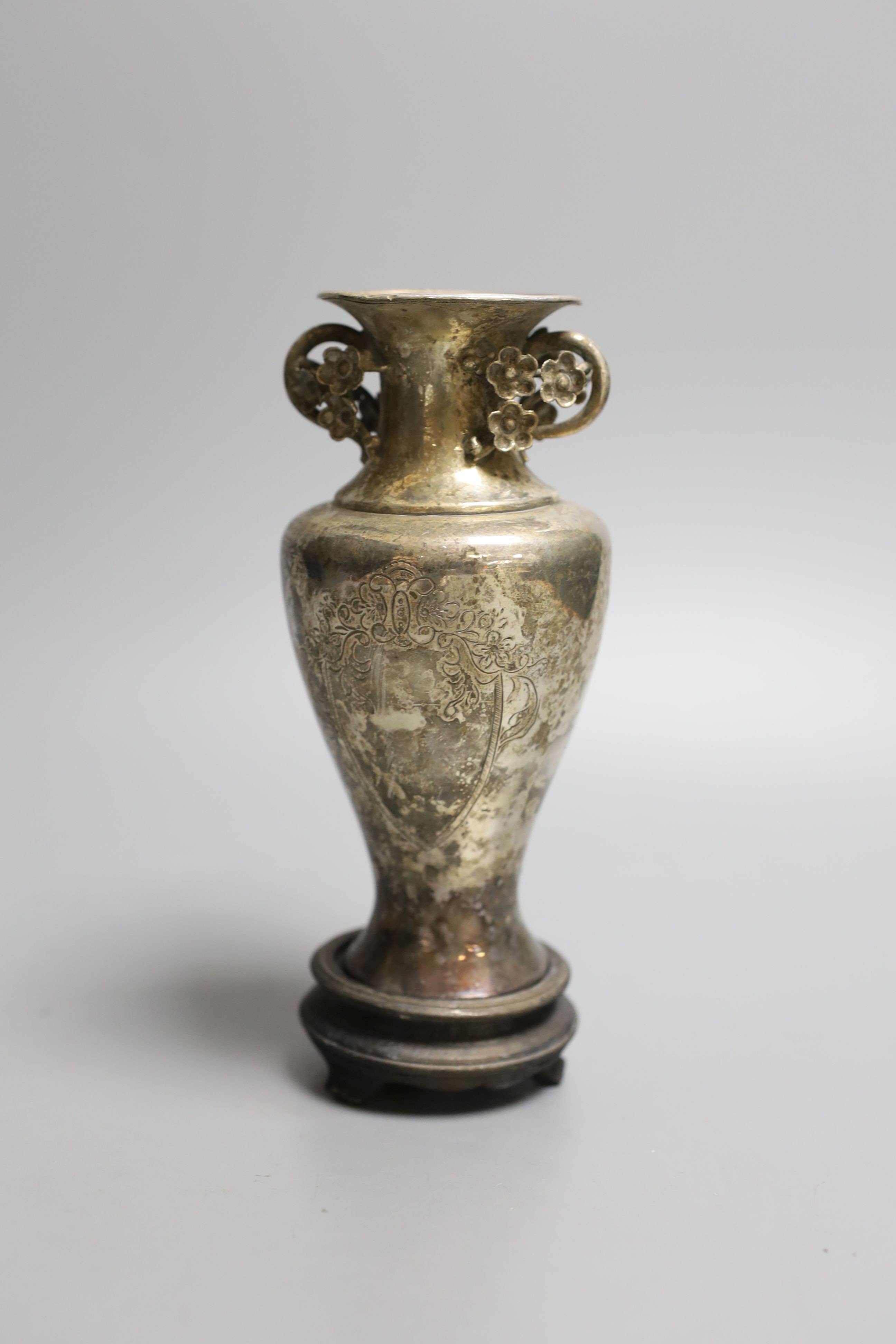 An early 20th century Chines engraved white metal two handled vase, on a wooden stand, vase 13.5cm.